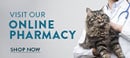 A large tabby cat is being held by a veterinarian in a white coat with a stethoscope. The text on the left side of the image reads "Visit Our Online Pharmacy" and "Shop Now.